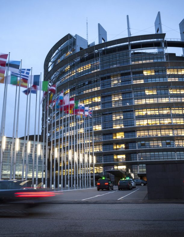 Strasbourg, France - October 24, 2013: Entrance of the main building of European Parliament in Strasbourg.  Completed in 1999 the building is the seat of the European Parliament (other work places are Luxembourg and Brussels). It was named after Louise Weiss (1893 - 1983) which was a French author, journalist, feminist and European politician. Some taxis and pedestrians in the foreground